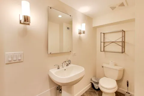 a bathroom with a sink a toilet and mirror