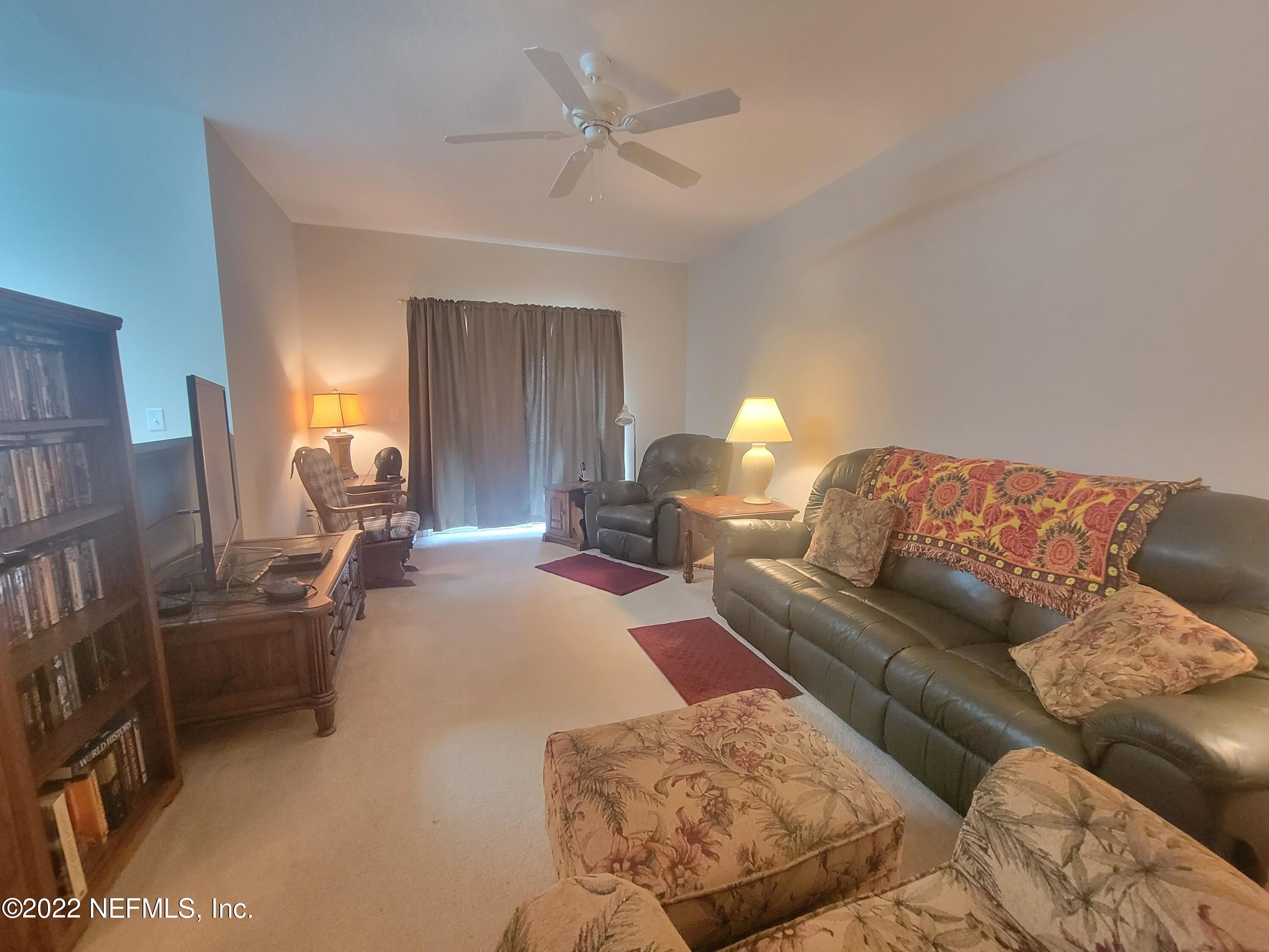 5260 Collins Road, Unit 605 Jacksonville, FL 32244 - Photo 3 of 13 a living room with furniture and a lamp