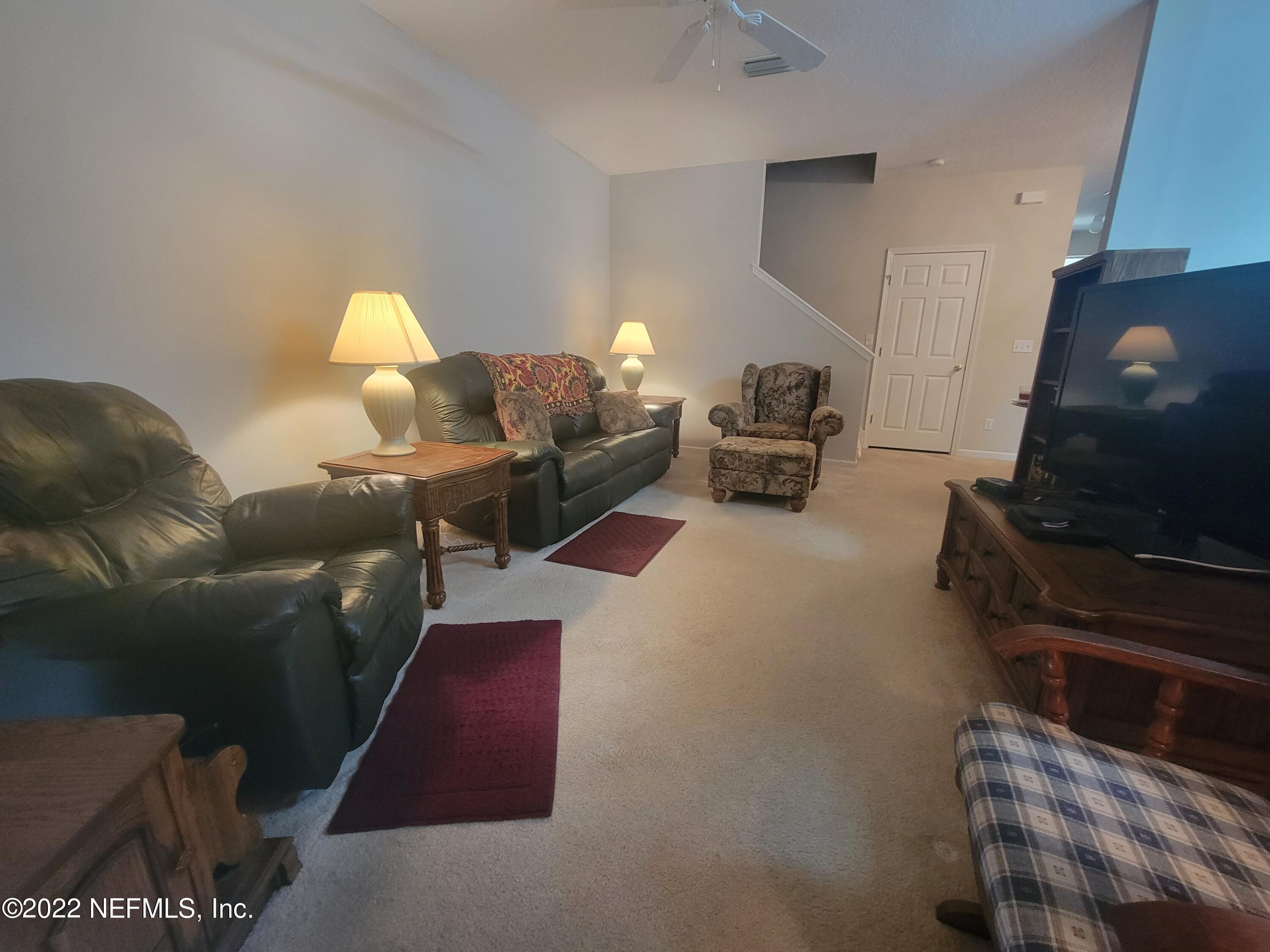 5260 Collins Road, Unit 605 Jacksonville, FL 32244 - Photo 4 of 13 a living room with furniture and a flat screen tv