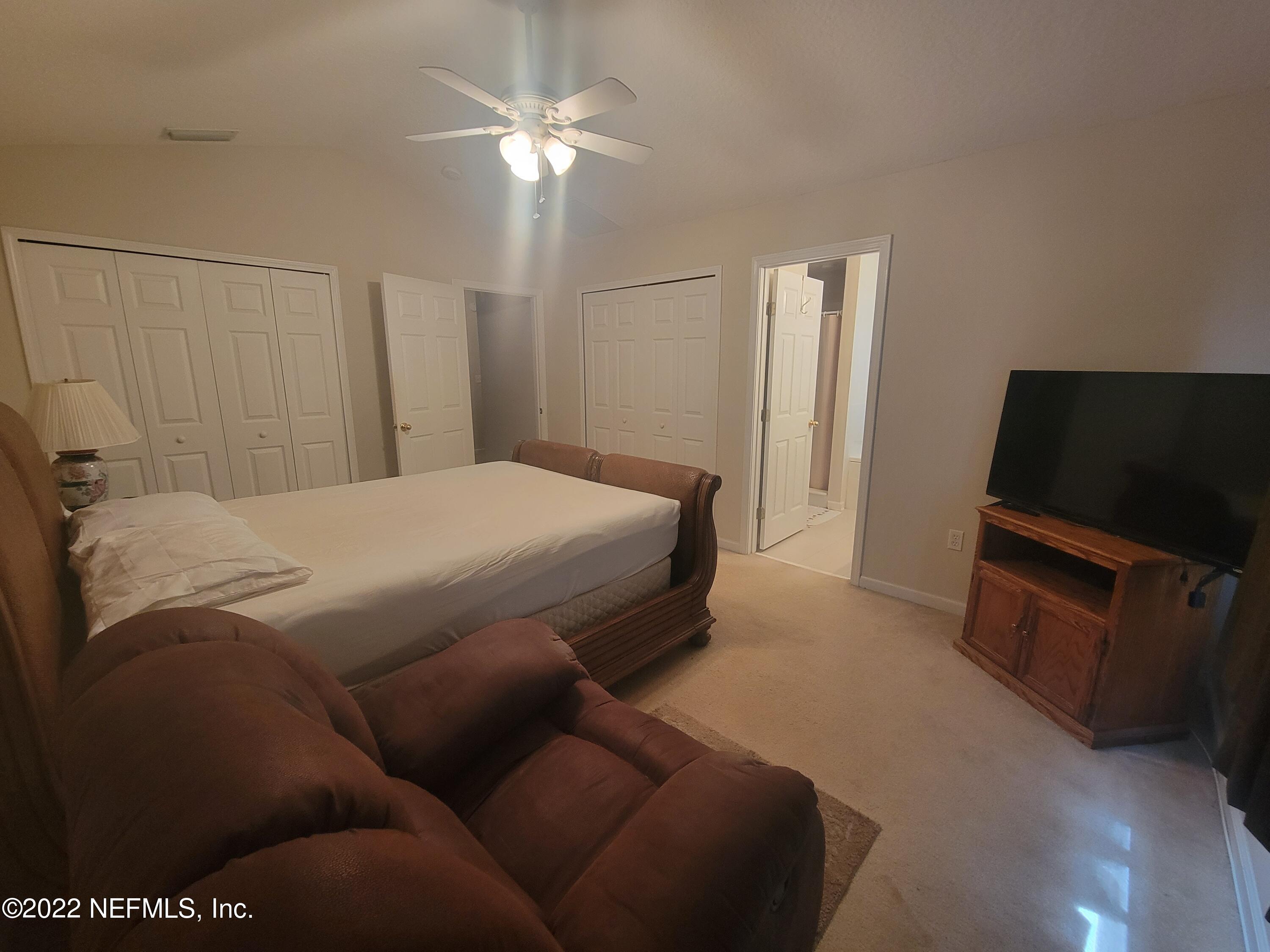5260 Collins Road, Unit 605 Jacksonville, FL 32244 - Photo 6 of 13 a bedroom with a bed and a television