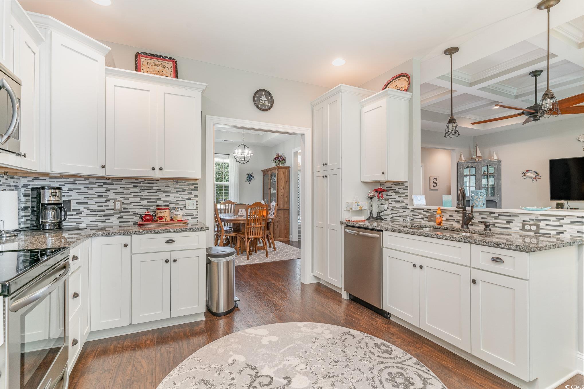 Kitchen with stainless steel appliances, dark hard