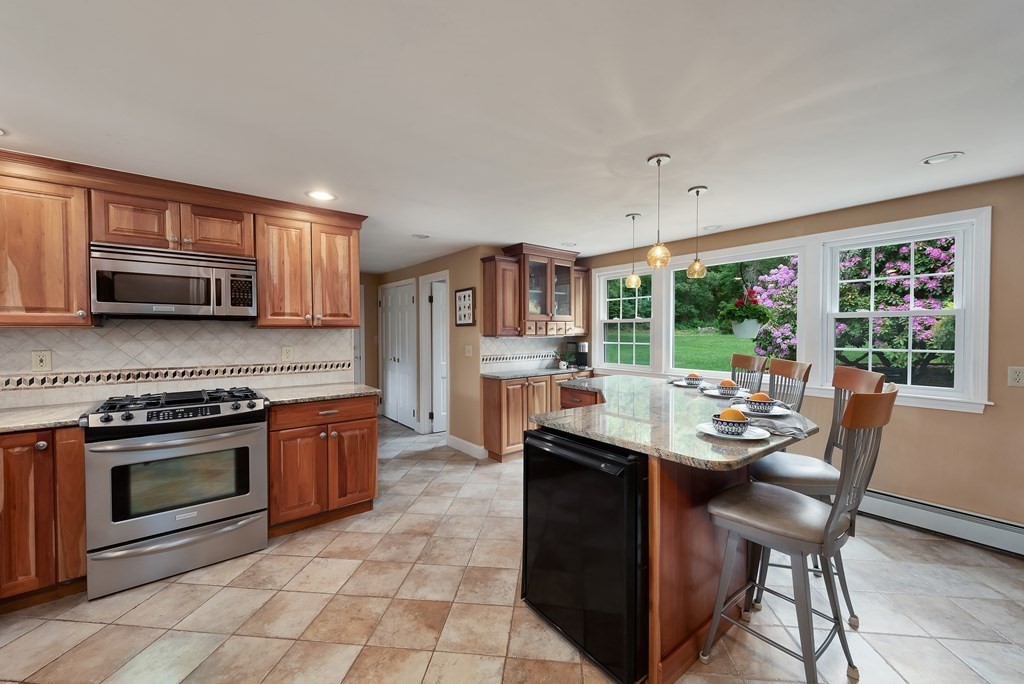 6 Trask Road Boxford, MA 01921 - Photo 4 of 36 a kitchen with stainless steel appliances granite countertop a stove top oven a sink dishwasher a dining table and chairs with wooden floor