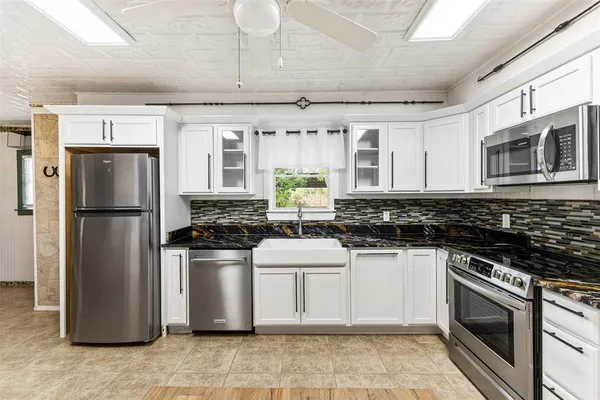 a kitchen with stainless steel appliances granite countertop a stove sink and microwave