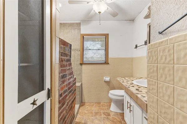 an empty room with windows and chandelier fan