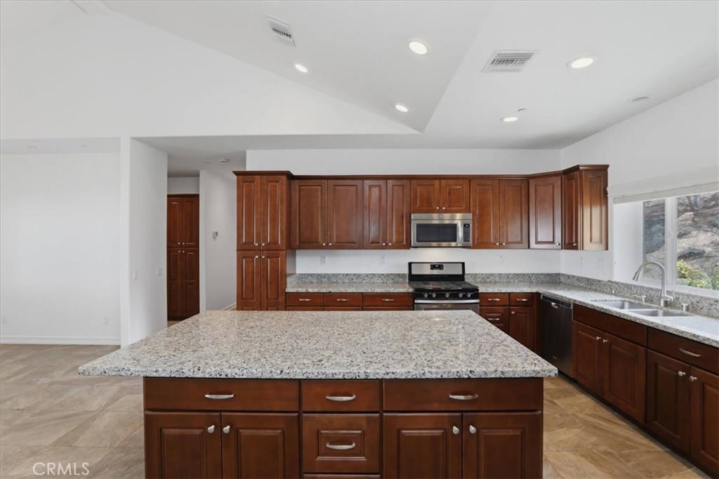 14202 Meadowlands Drive Riverside, CA 92503 - Photo 16 of 60 a kitchen with a sink a counter top space cabinets and stainless steel appliances
