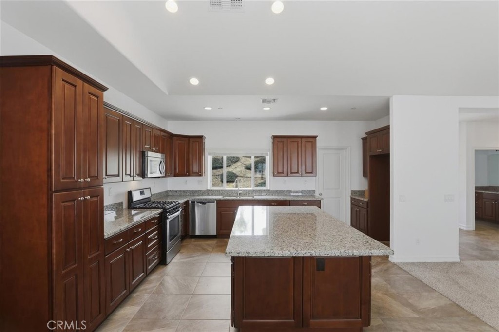 14202 Meadowlands Drive Riverside, CA 92503 - Photo 17 of 60 a kitchen with stainless steel appliances granite countertop lots of counter top space and wooden floor