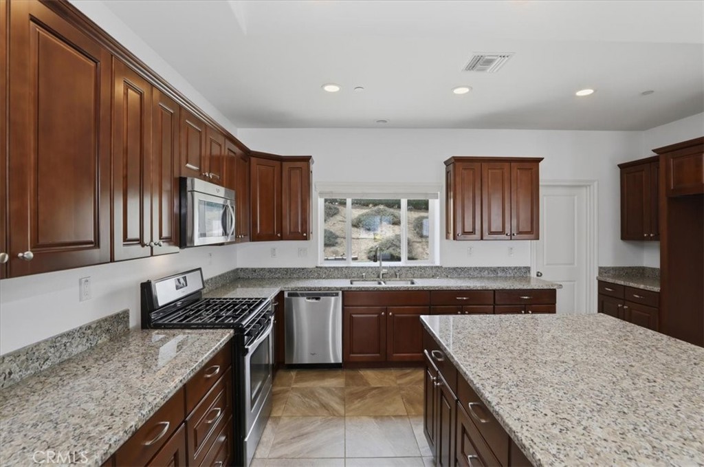 14202 Meadowlands Drive Riverside, CA 92503 - Photo 18 of 60 a kitchen with granite countertop stainless steel appliances and wooden cabinets
