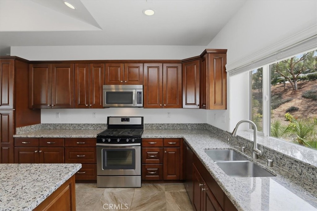 14202 Meadowlands Drive Riverside, CA 92503 - Photo 19 of 60 a kitchen with granite countertop a stove sink and microwave