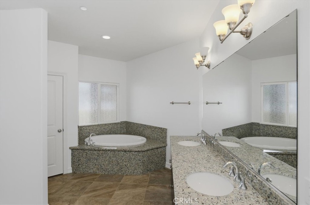 14202 Meadowlands Drive Riverside, CA 92503 - Photo 27 of 60 a bathroom with a granite countertop sink a toilet a mirror and shower