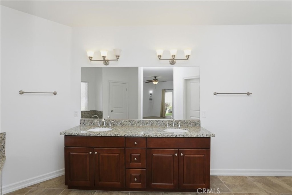 14202 Meadowlands Drive Riverside, CA 92503 - Photo 28 of 60 a bathroom with a granite countertop sink and a mirror