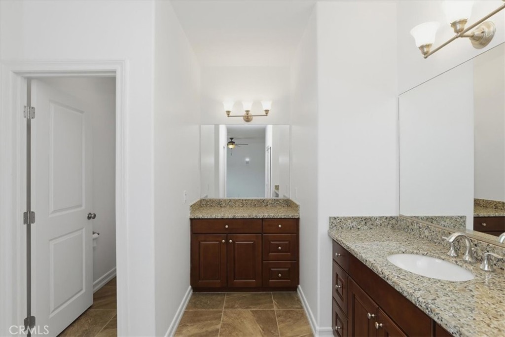 14202 Meadowlands Drive Riverside, CA 92503 - Photo 33 of 60 a bathroom with a granite countertop sink and a mirror