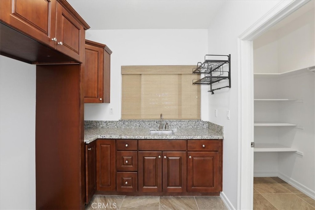 14202 Meadowlands Drive Riverside, CA 92503 - Photo 57 of 60 a bathroom with a granite countertop sink and a mirror