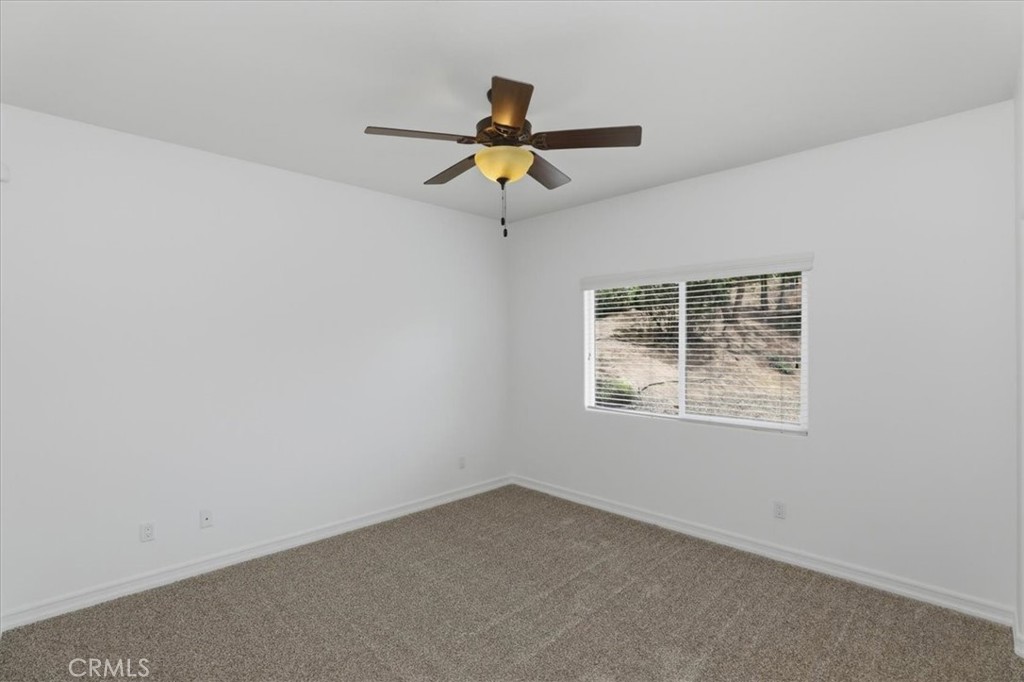 14202 Meadowlands Drive Riverside, CA 92503 - Photo 59 of 60 an empty room with wooden floor a ceiling fan and a window
