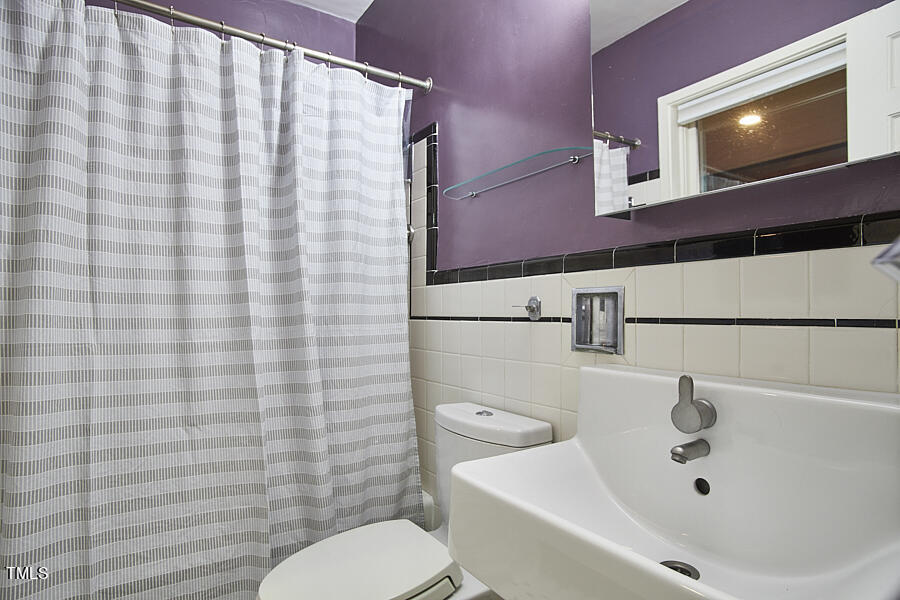 2620 Fairview Road Raleigh, NC 27608 - Photo 18 of 31 a bathroom with a sink a toilet and shower curtain