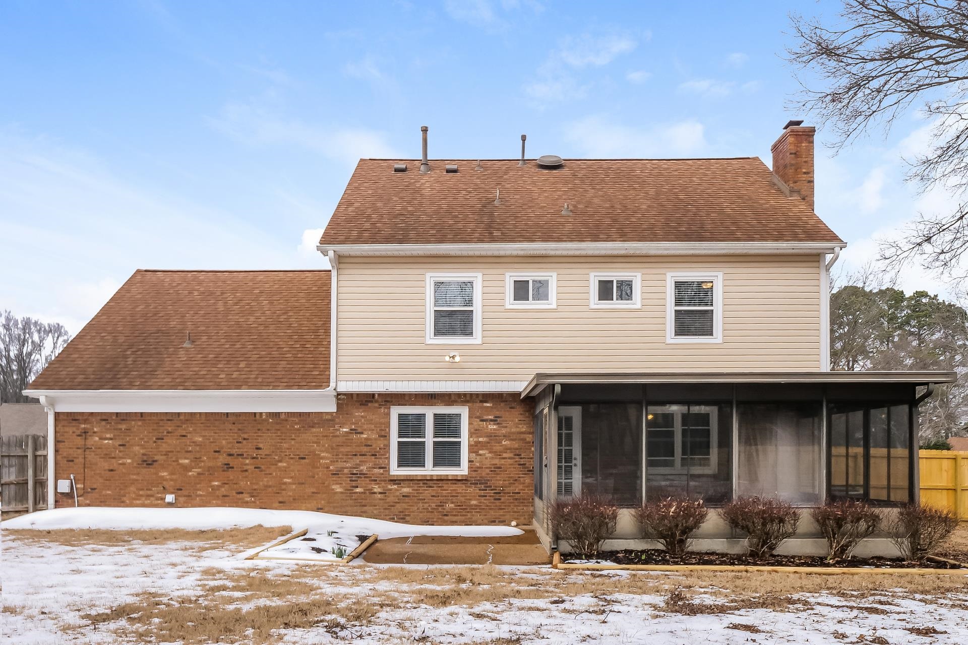 207 East Pecan Valley Street Collierville, TN 38017 - Photo 10 of 18 Snow covered back of property with a chimney, roof with shingles, a sunroom, and brick siding