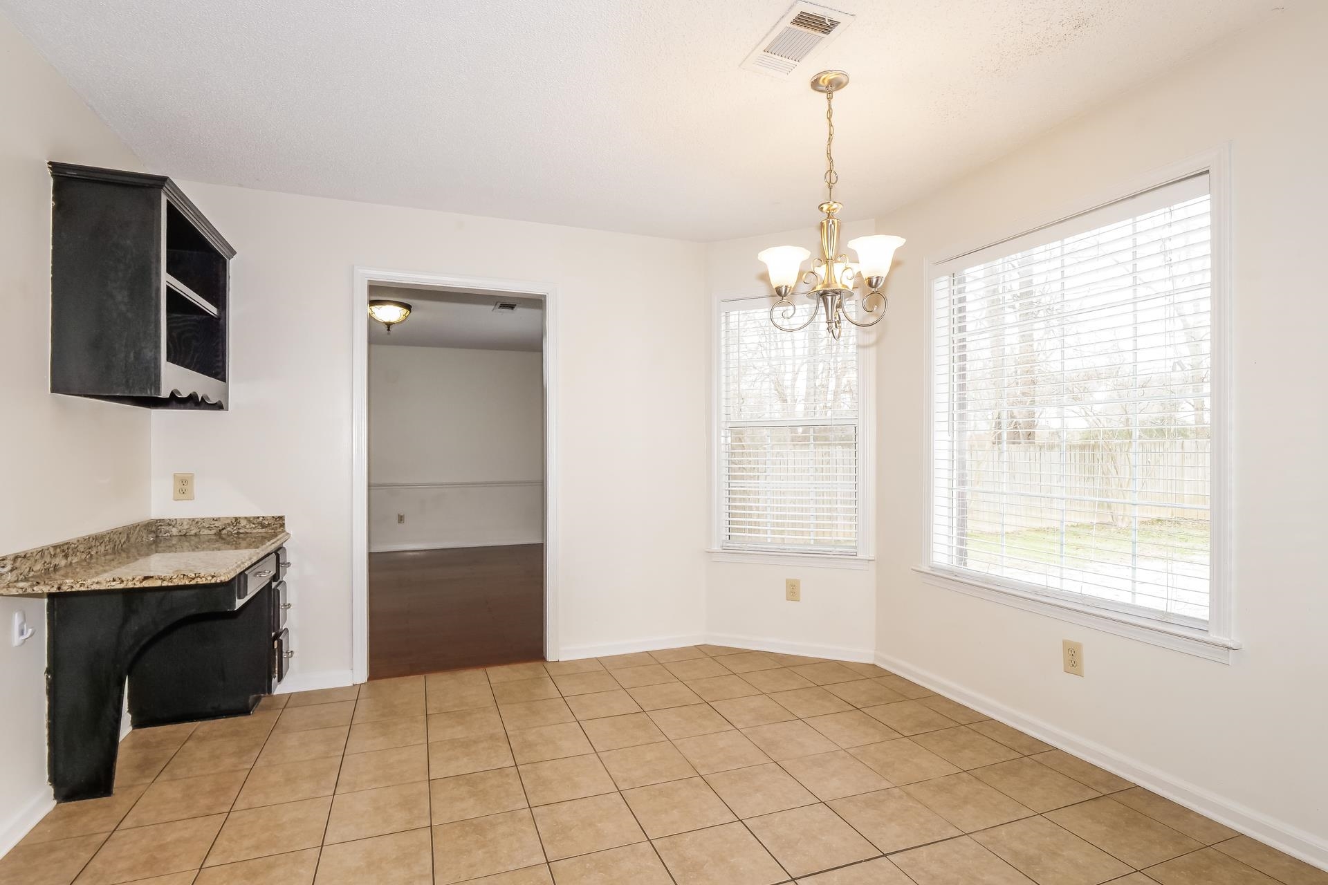 207 East Pecan Valley Street Collierville, TN 38017 - Photo 15 of 18 Unfurnished dining area with a chandelier and light tile patterned flooring