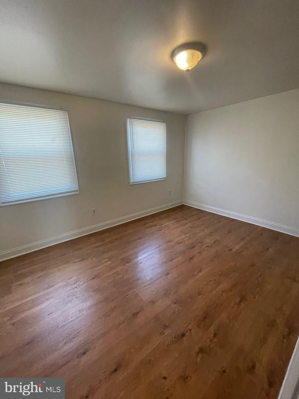 109 Carver Road Dundalk, MD 21222 - Photo 13 of 23 an empty room with wooden floor and windows