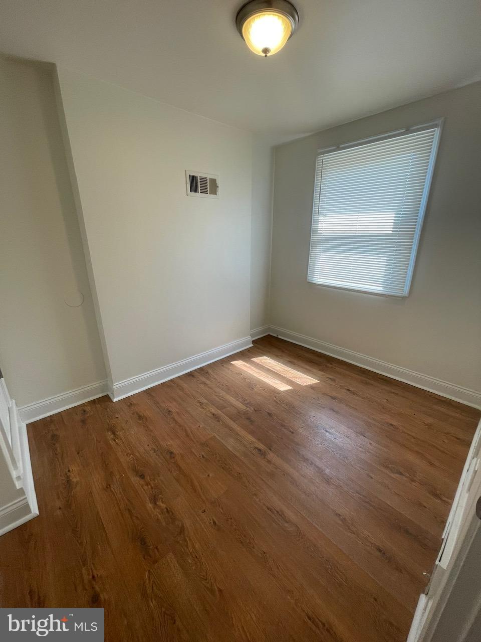 109 Carver Road Dundalk, MD 21222 - Photo 15 of 23 an empty room with wooden floor and windows