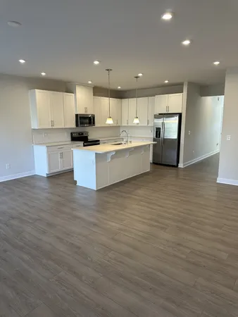 a large kitchen with stainless steel appliances granite countertop a stove a sink and a refrigerator