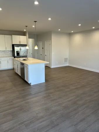 a large kitchen with stainless steel appliances granite countertop a large counter top a sink and a stove