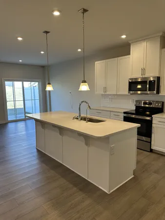 a large kitchen with stainless steel appliances granite countertop a sink a stove and a wooden floors