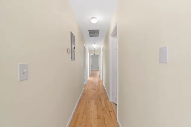a view of a hallway with wooden floor