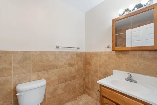 a bathroom with a toilet sink and mirror