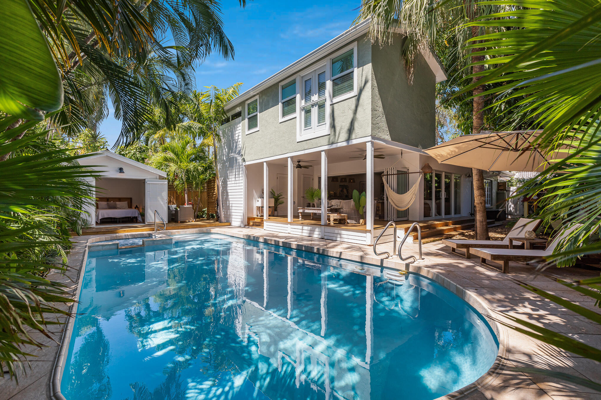 a view of a house with pool and chairs