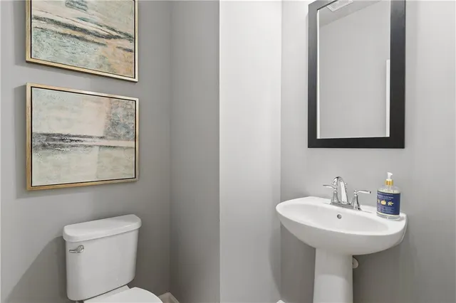 a bathroom with a toilet a sink and mirror