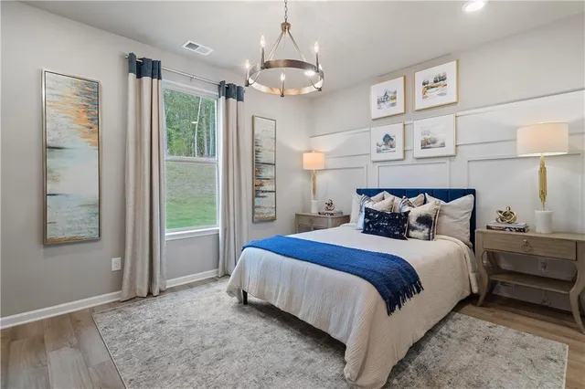 a spacious bedroom with a bed and a chandelier