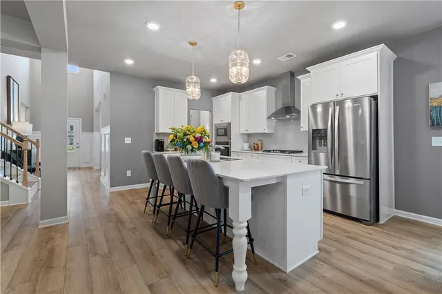 a kitchen with stainless steel appliances a refrigerator sink wooden floor and a stove