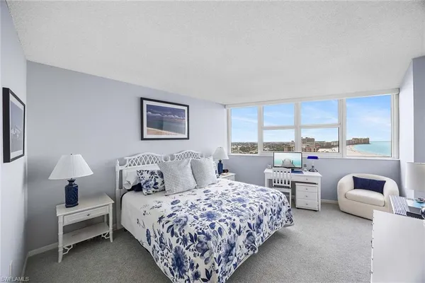 a bedroom with furniture and large windows
