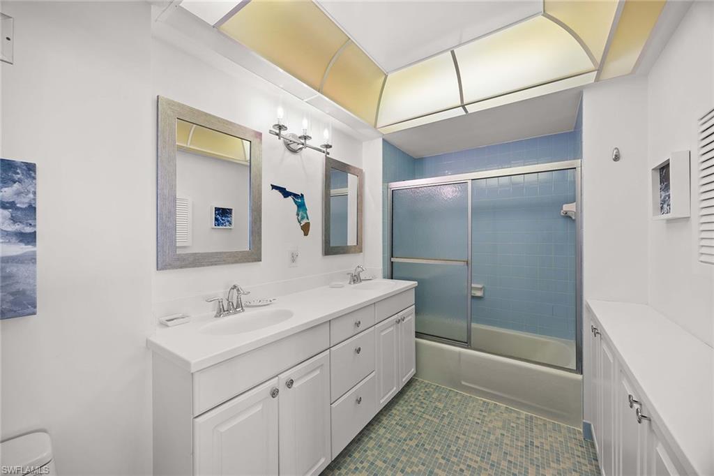 58 North Collier Boulevard, Unit 2101 Marco Island, FL 34145 - Photo 18 of 30 a bathroom with a double vanity sink mirror double and shower