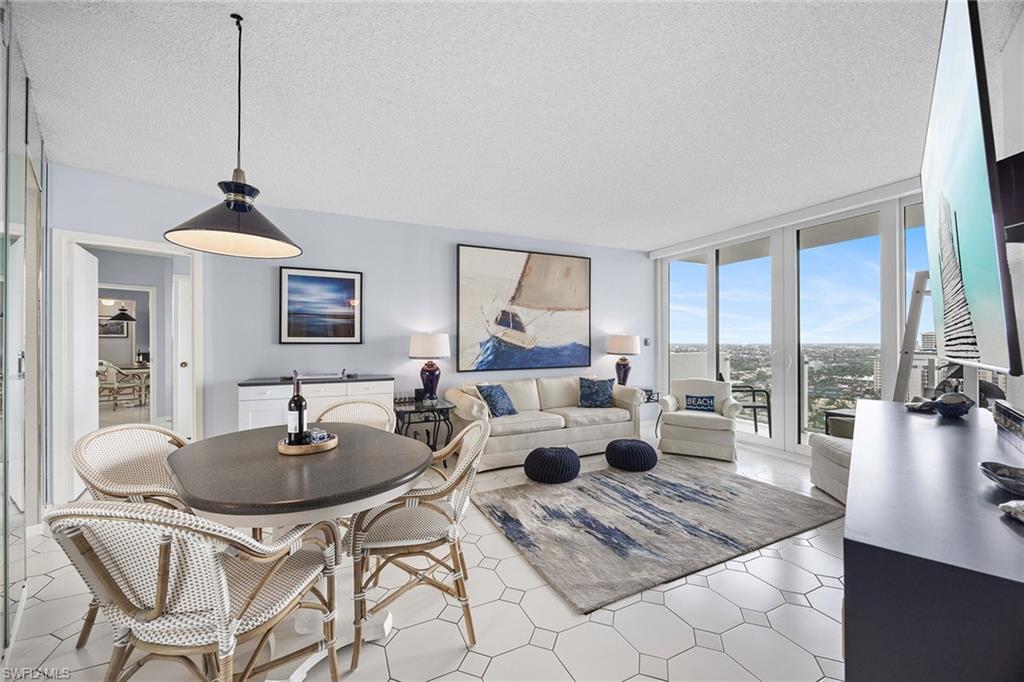58 North Collier Boulevard, Unit 2101 Marco Island, FL 34145 - Photo 8 of 30 a living room with furniture a rug a chandelier and a large window