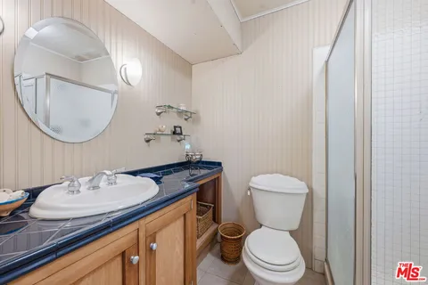 a bathroom with a granite countertop toilet sink and mirror