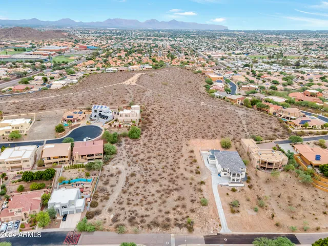 a view of a dry yard with wooden fence