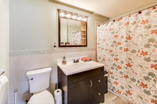 a bathroom with a sink vanity mirror and toilet