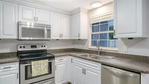 a kitchen with cabinets appliances a sink and a counter top space