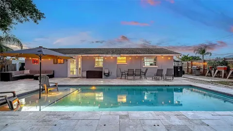 a view of a swimming pool with outdoor seating and a table and chairs