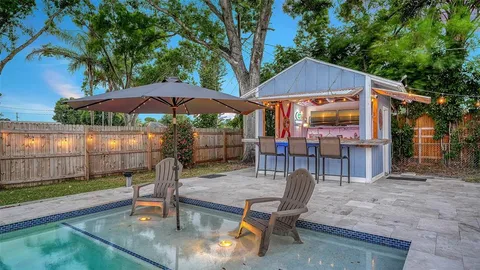 a patio with a table and chairs under an umbrella
