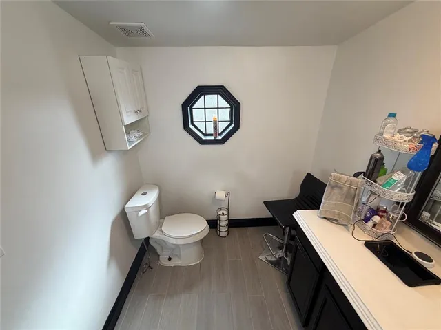 a bathroom with a toilet a sink and a mirror