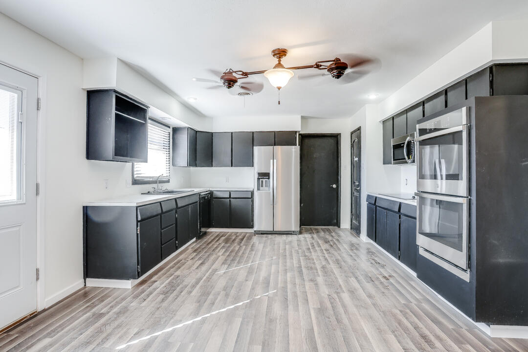 2123 66th Street Lubbock, TX 79412 - Photo 6 of 16 a kitchen with stainless steel appliances a refrigerator sink and stove