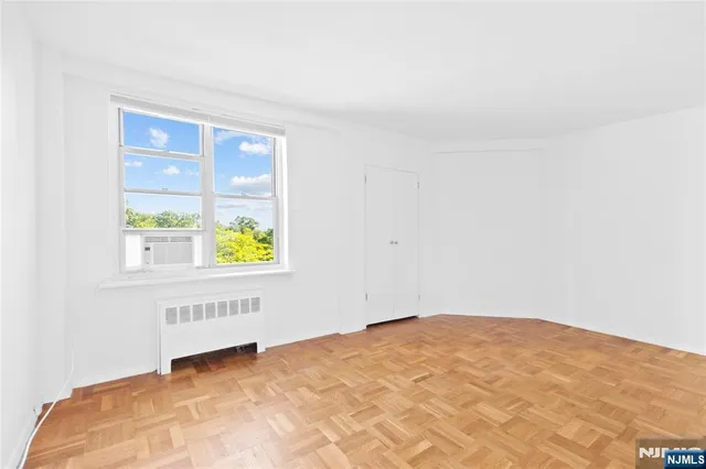 a bedroom with a bed a chandelier and a window