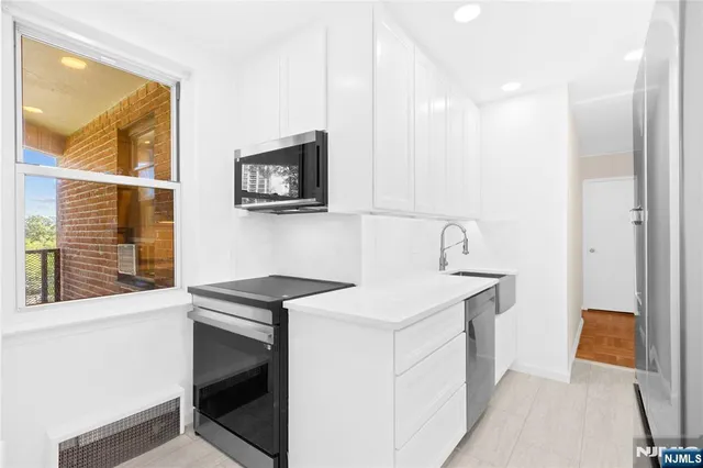a hallway with painting on the wall and a refrigerator