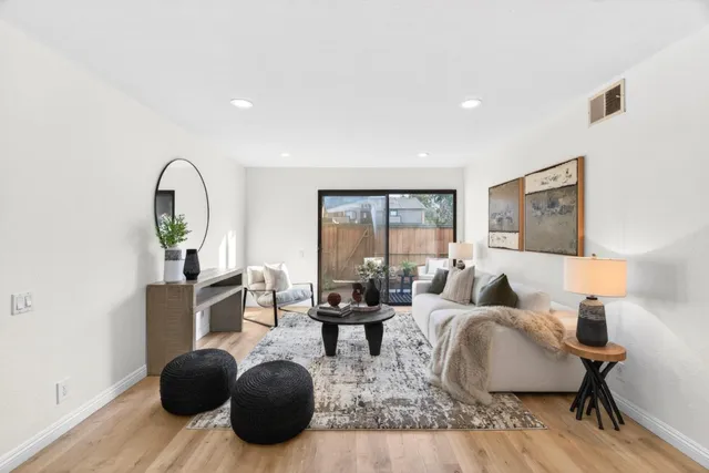 a living room with furniture a table and wooden floor