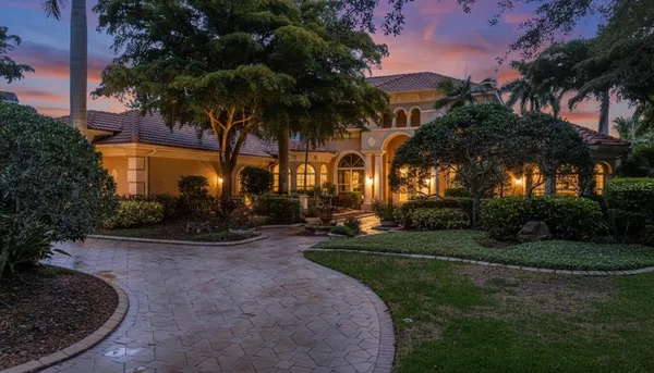 a view of a house with a yard and potted plants