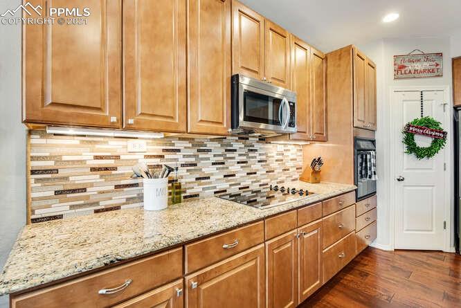 13873 Windy Oaks Road Colorado Springs, CO 80921 - Photo 14 of 28 a kitchen with stainless steel appliances wooden cabinets and a counter top space