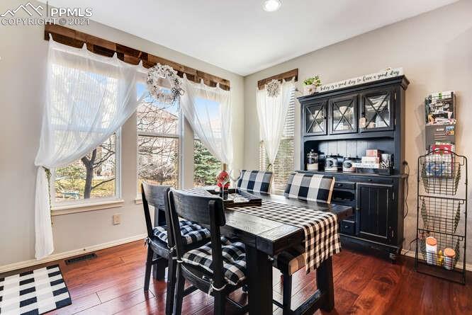 13873 Windy Oaks Road Colorado Springs, CO 80921 - Photo 15 of 28 a view of a dining room with furniture window and wooden floor