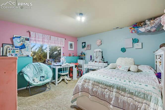 13873 Windy Oaks Road Colorado Springs, CO 80921 - Photo 21 of 28 a bedroom with a bed and a table in it