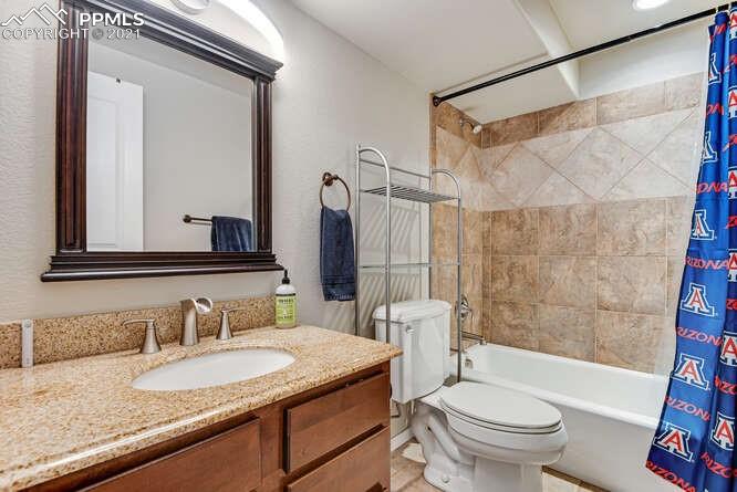 13873 Windy Oaks Road Colorado Springs, CO 80921 - Photo 22 of 28 a bathroom with a granite countertop sink toilet mirror and shower
